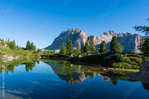 Fototapeta Naklejka Na Ścianę i Meble -  Panoramic view of idyllic summer landscape in the Alps with clear mountain lake and fresh green mountain pastures in the background