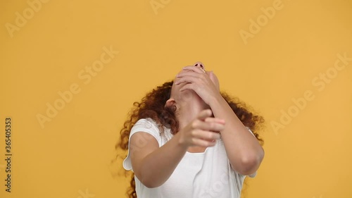 Young fun african woman girl 20s in white t-shirt posing isolated on yellow background studio. People sincere emotions lifestyle concept. Looking camera cheerful laughing smile watching comedy movie