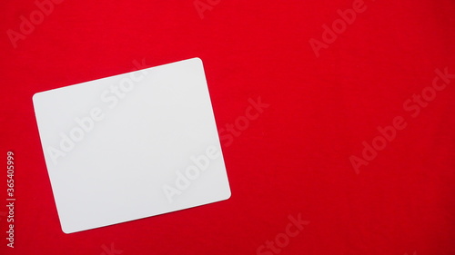 White blank paper card on red fabric background for add text and things to do. Copy space for making memo and reminder list