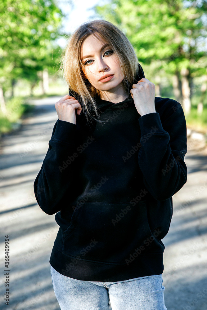 blonde woman in black hoodie posing in the park, mock up clothes for printing