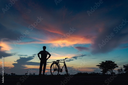 silhouette of a man riding a bicycle