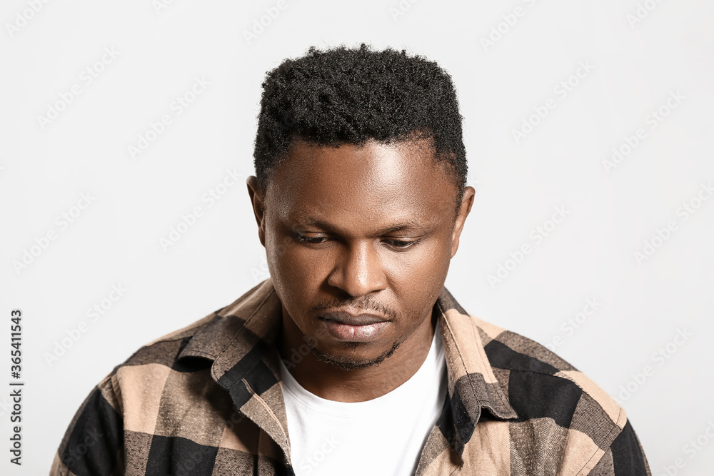 Obraz premium Sad African-American man on light background. Stop racism