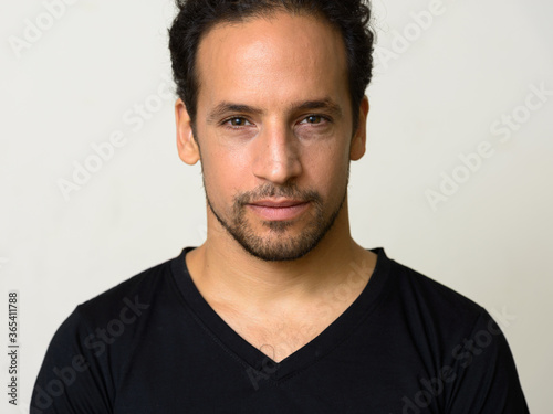 Portrait of handsome bearded Hispanic man with curly hair © Ranta Images