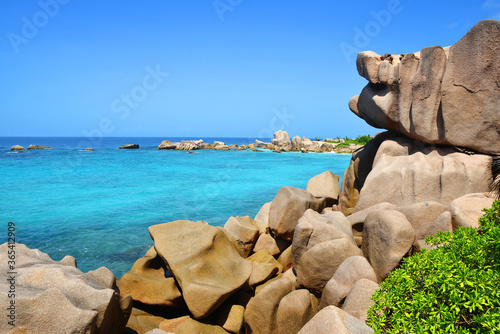 Coast near Anse Marron beach with big granite boulders on La Digue Island, Seychelles. Tropical landscape with sunny sky. Luxury travel destination.