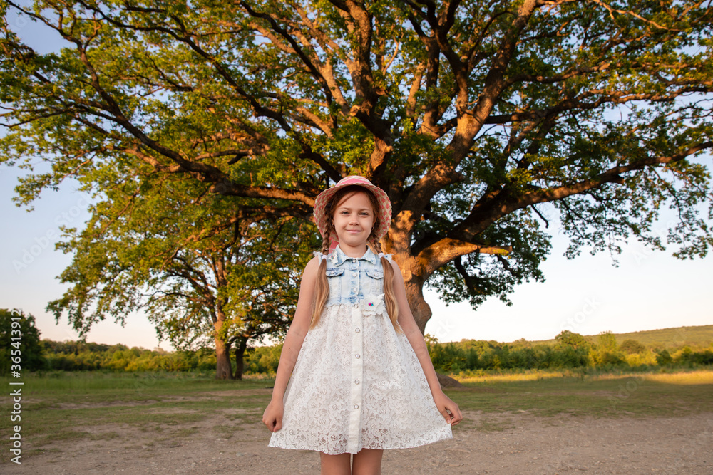 Huge Tree. a little girl by a big tree. child near with large green old oak