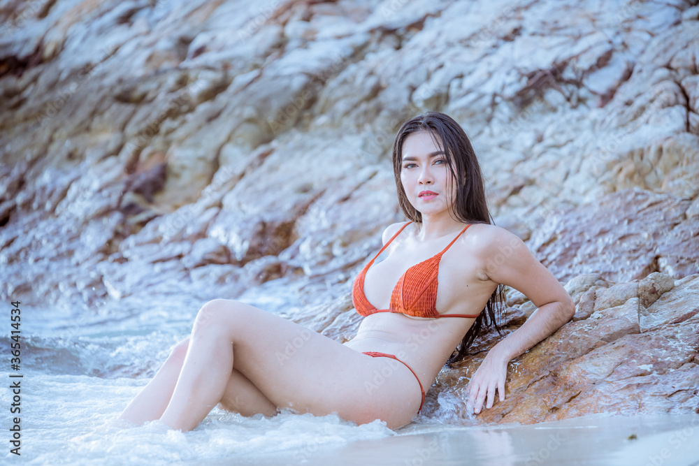 Fototapeta premium Portrait beautiful young model asian woman wearing swimming suite bikini posing sexy feel happy on the sea ocean beach for leisure travel vacation on summer season.