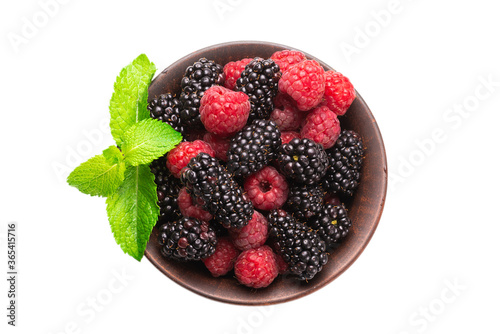 Raspberry, blackberry and mint leaf in ceramic brown bowl isolated on white