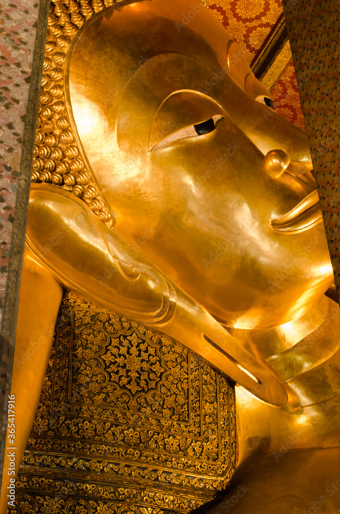 Face of The Golden Reclining Buddha Statue of Wat Pho Monastery in Bangkok, Thailand.