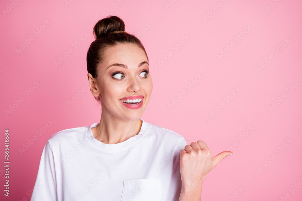 Photo of attractive lady bun hairdo look direct thumb finger side empty space showing sale discount proposition shopping season wear white t-shirt isolated pastel pink color background Photo of attractive lady bun hairdo look direct thumb finger side empty space showing sale discount proposition shopping season wear white t-shirt isolated pastel pink color background