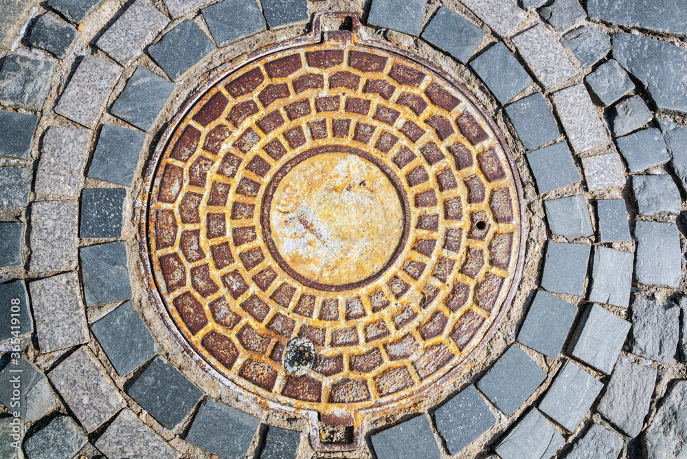 Close up of old sewer manhole cover on the urban road. Close up of old sewer manhole cover on the urban road.