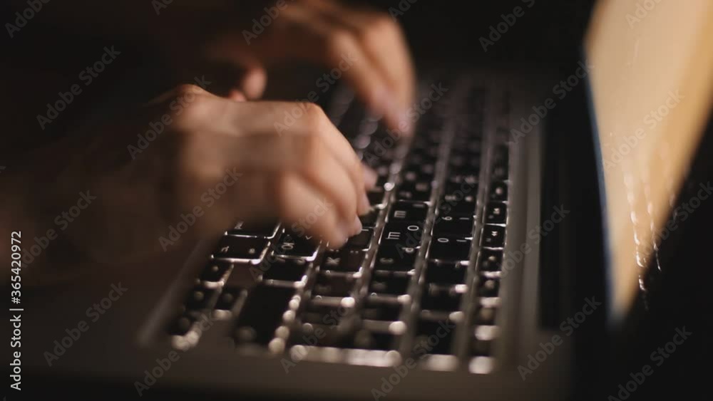 Hands typing on a keyboard in darkness Hands typing on a keyboard in darkness