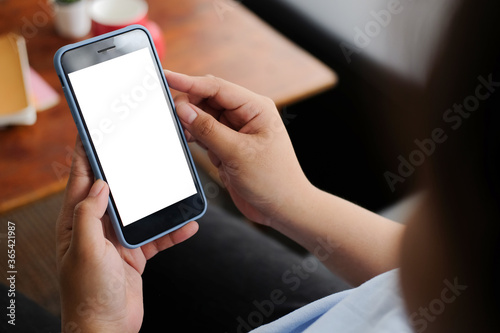 Cropped shot view of man hands holding smart phone with blank copy space screen for your text message or information content, female reading text message on cell telephone during in urban setting. 
