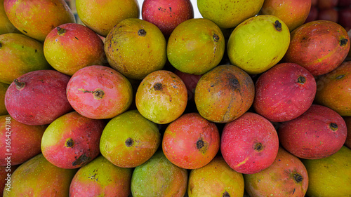 Heap of fresh ripe mangoes in a market, close up photo