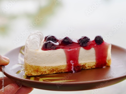 Blueberry cheesecake on a brown plate. 