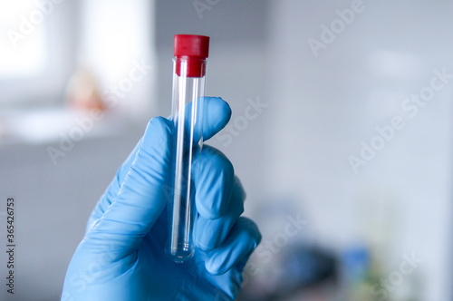 Medical worker in protective glove holds a medical test tubes for analysis