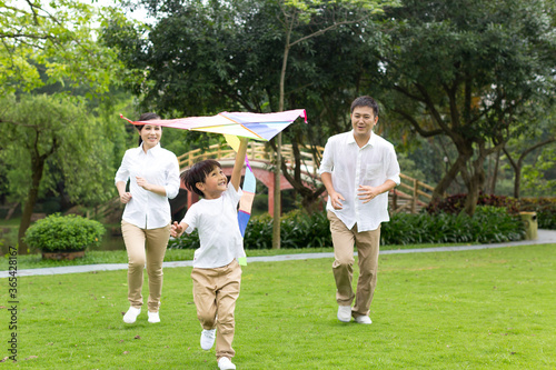 Happy family  flying kite in the park