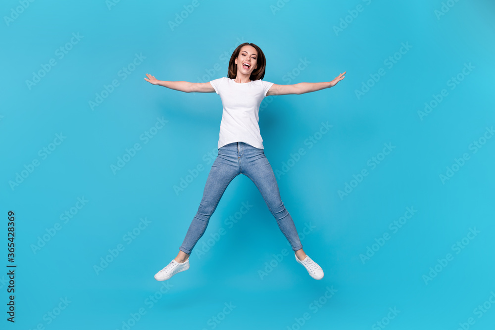 Full length body size view of her she nice attractive pretty funky careless childish playful skinny cheerful girl jumping having fun isolated bright vivid shine vibrant blue color background Full length body size view of her she nice attractive pretty funky careless childish playful skinny cheerful girl jumping having fun isolated bright vivid shine vibrant blue color background