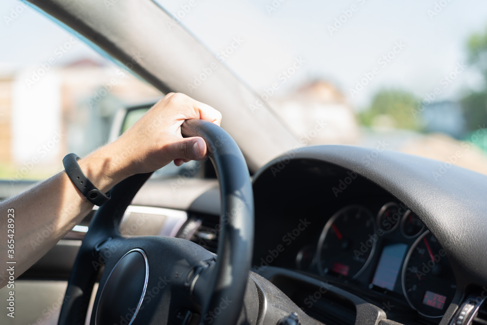 Driver hand on the car steering wheel close up.