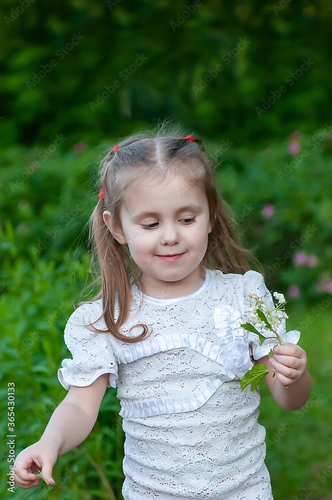 beautiful three year old girl examines a beautiful flower in the park beautiful three year old girl examines a beautiful flower in the park