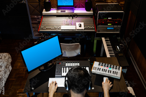 back of asian producer, sound engineer working in recording, broadcasting studio