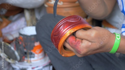 Painting a handmade clay ashtray in Bangladesh.  These finishing touches are applied on the roadside just outside the store in Dhaka. photo