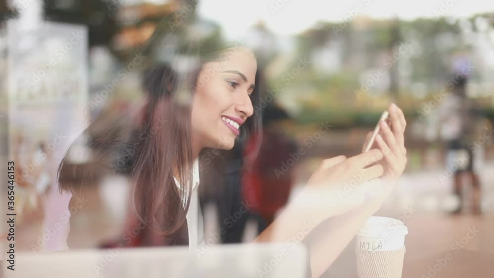 Young beautiful Indian woman using her mobile phone