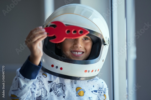 Child playing with astronaut helmet and toy rocket