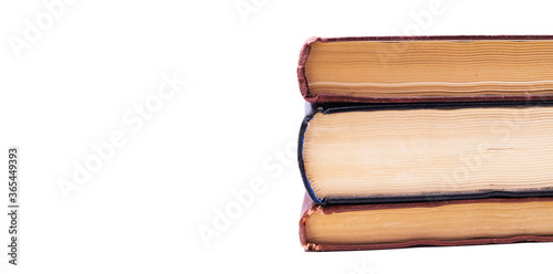 Three old books lie one on one  a pile from the side on a white background top view in profile. The top of the book on a white background lies