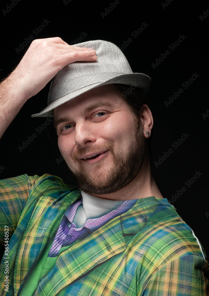 portrait of good looking fooling around bearded man in checkered blazer taking off stylish hat and looking at camera isolated on black portrait of good looking fooling around bearded man in checkered blazer taking off stylish hat and looking at camera isolated on black