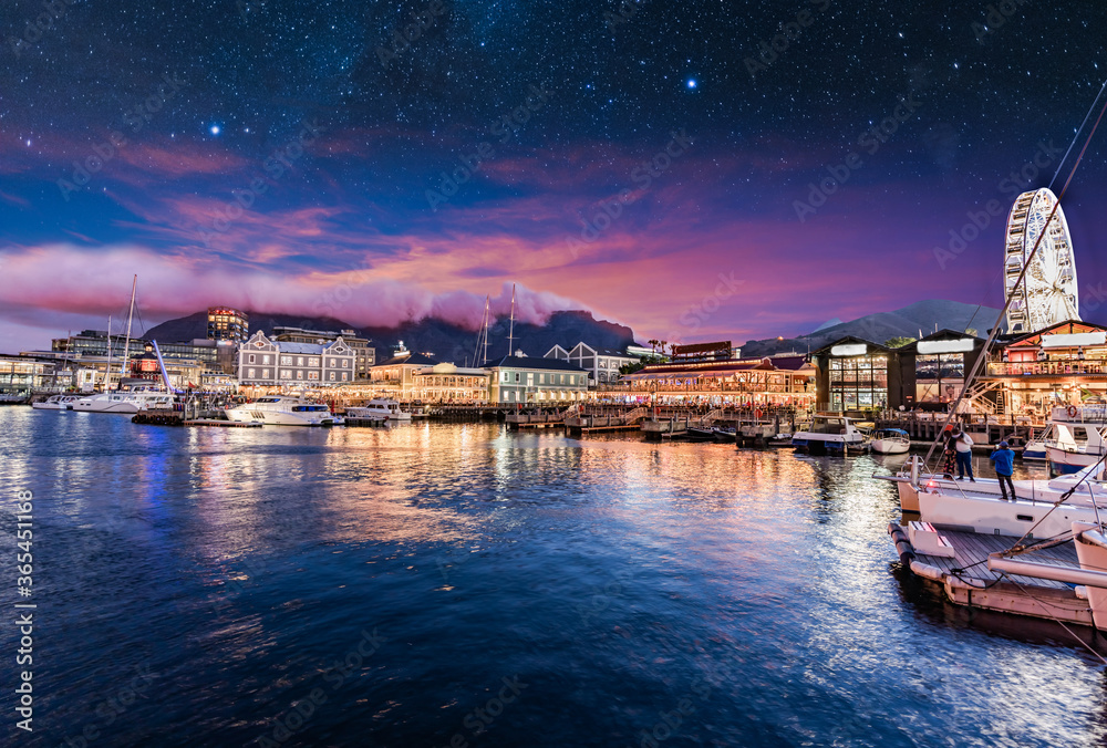 Obraz premium Illuminated Cape Town waterfront at night with stars in the sky