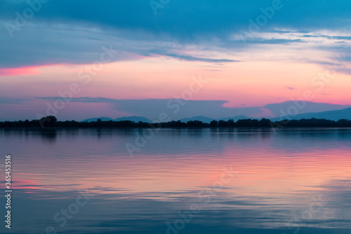 Sunset on the lake of Ptuj, Slovenia. Last light with clouds and sky reflected in the lake