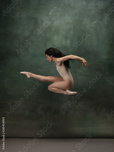 Target, achievement. Graceful classic ballerina dancing on dark studio background. Pastel bodysuit. The grace, artist, movement, action and motion concept. Looks weightless, flexible. Fashion, style.