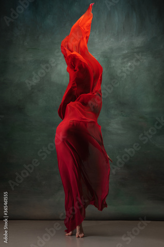 Fototapeta Naklejka Na Ścianę i Meble -  Fire flame. Graceful classic ballerina dancing on dark studio background. Deep red cloth. The grace, artist, movement, action and motion concept. Looks weightless, flexible. Fashion, style.