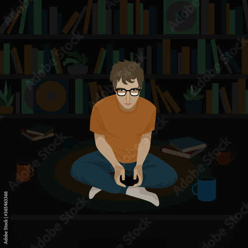 A young man in the dark room playing a console sitting on the floor in front of the TV screen.