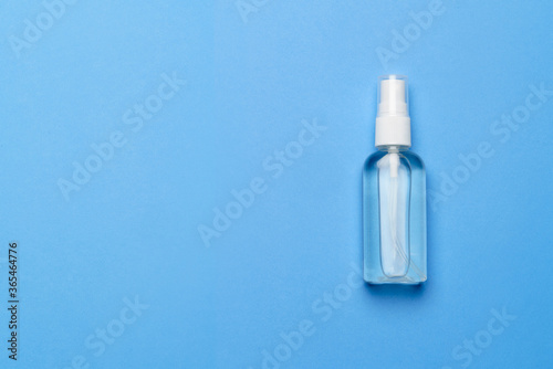 Bottle of antiseptic alcohol hand sanitize spray on a blue background for the prevention of coronavirus - flat layout with copy space