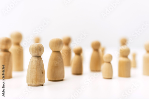 Group of confused grouped people, represented by wooden figures, isolated in studio on white background.