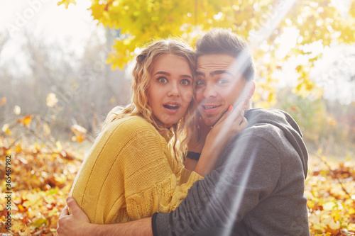 Happy young couple outdoors on a beautiful autumn day in the forest