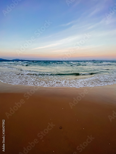 Fototapeta Naklejka Na Ścianę i Meble -  Seascape, sea view. Waves at sea, sea tide, sandy shore. Clouds in the sky. Sea sunset, colorful sky