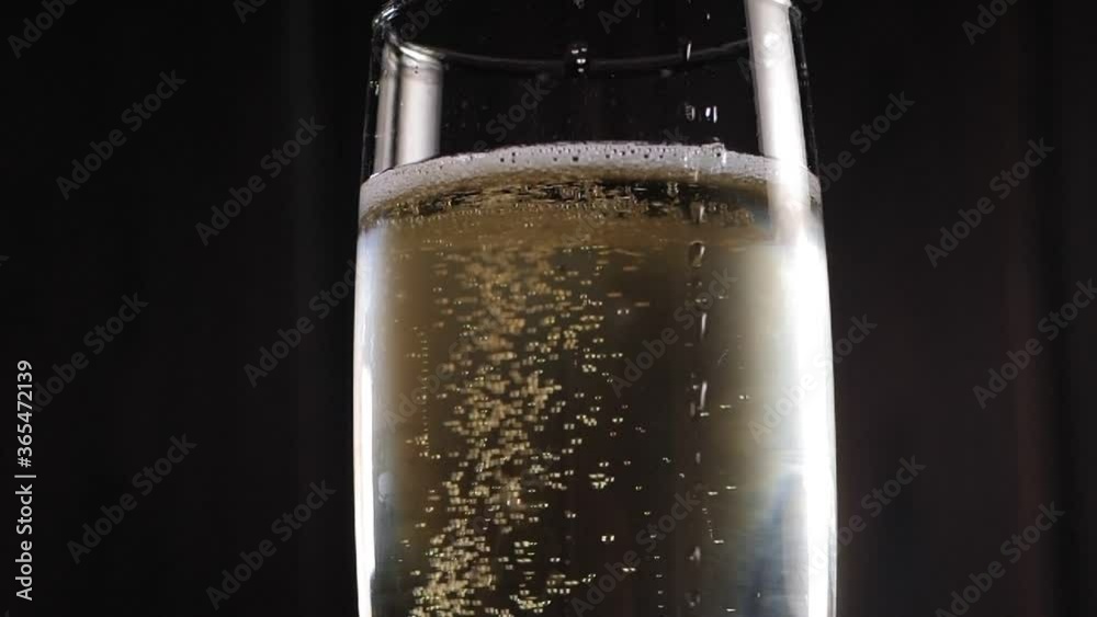 Close-up of a glass of champagne slowly spinning in the background with lights. Slow motion. Close-up of a glass of champagne slowly spinning in the background with lights. Slow motion.