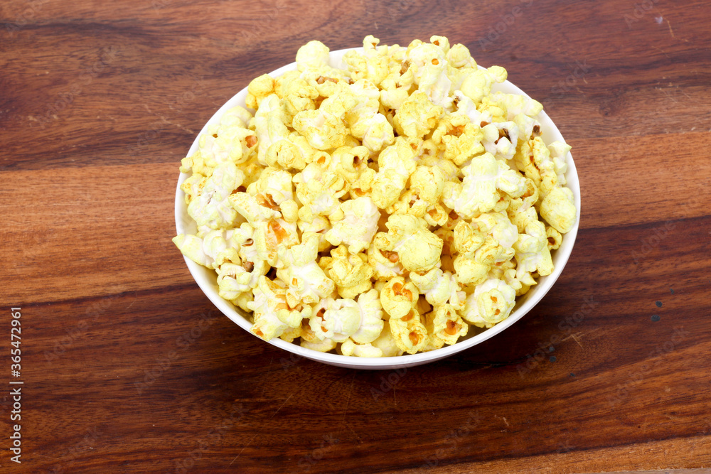 Tasty popcorn in a bowl on Wooden Background. Snack for a movie Tasty popcorn in a bowl on Wooden Background. Snack for a movie