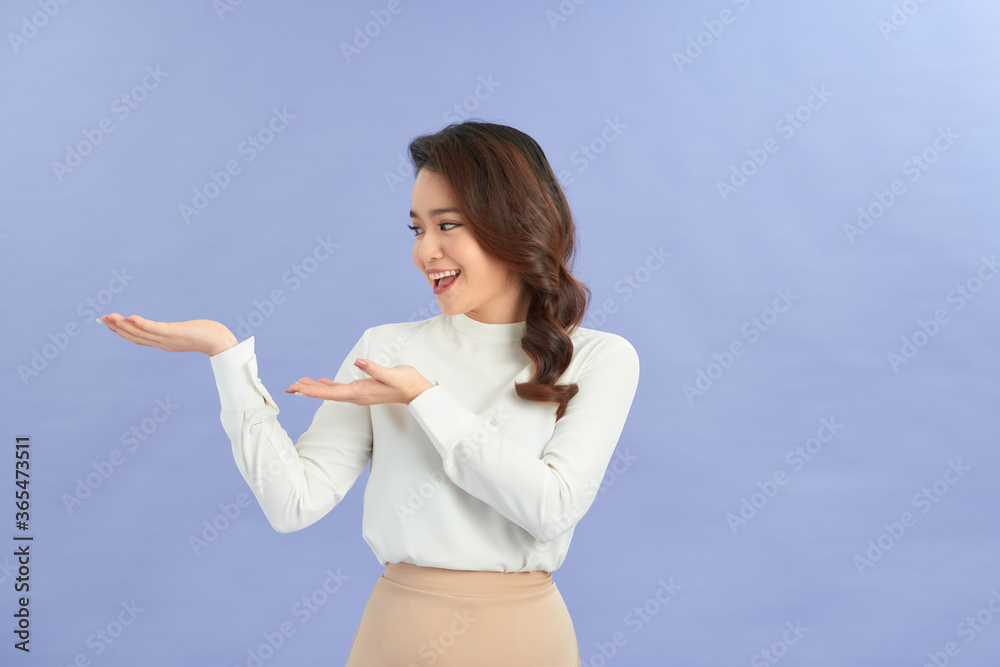 young girl holding copyspace imaginary on the palm to insert an ad on purple background young girl holding copyspace imaginary on the palm to insert an ad on purple background