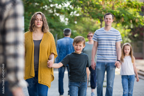 Smiling people of different ages walk in the park on holiday