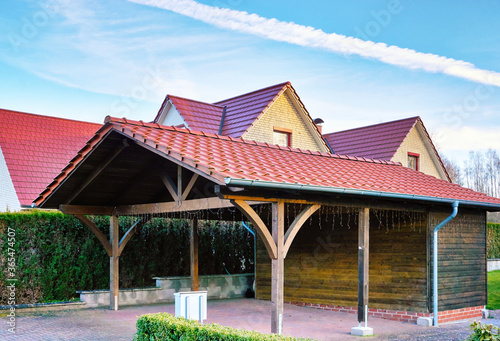 Wooden carport with red brick roof on a new house. photo