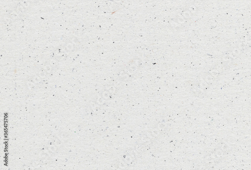 Close of view of grey paper recycled background with inclusions of paper particles. Extra large highly detailed image. Recycled paper concept.