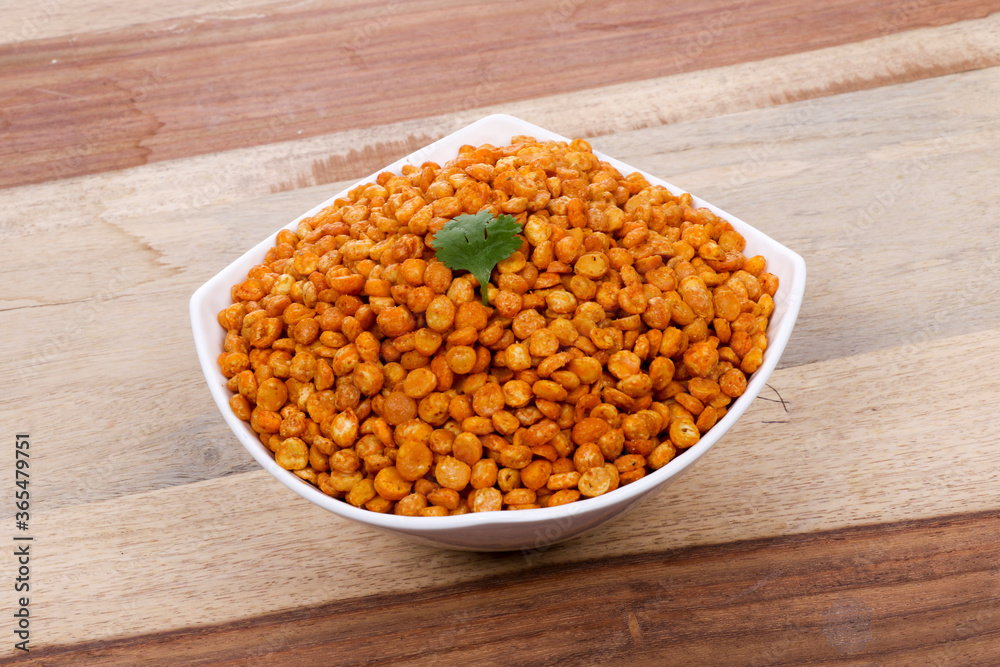 Fried and Spicy Chana Masala Dal, Chana Dal is a very popular Gujarati snack, white bowl on wooden background Fried and Spicy Chana Masala Dal, Chana Dal is a very popular Gujarati snack, white bowl on wooden background
