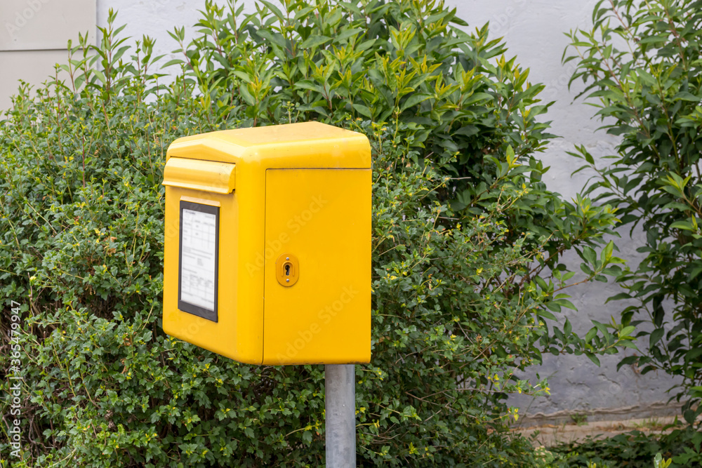 Briefkasten am Straßenrand vor einer Hecke Briefkasten am Straßenrand vor einer Hecke