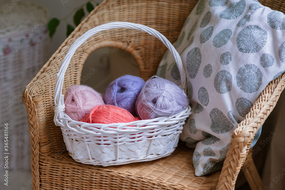 Yarn for knitting pastel shades in a basket. Close-up, knitting texture, needlework.
