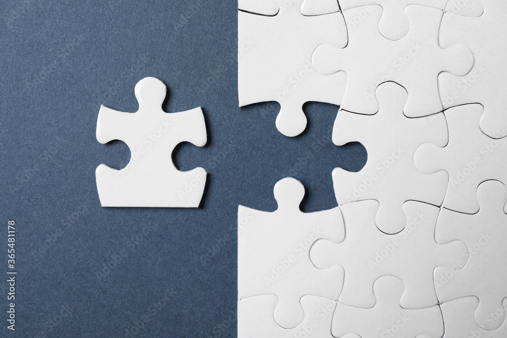 Blank white puzzle with separated piece on grey background, flat lay Blank white puzzle with separated piece on grey background, flat lay