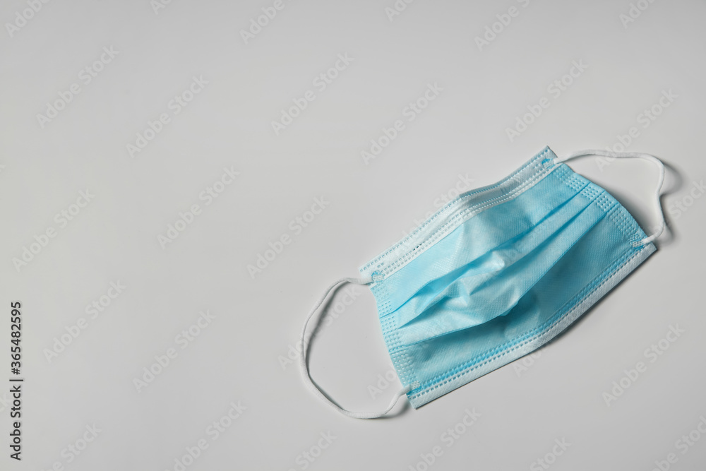 Disposable face mask on light background, top view with space for text. Protective measures during coronavirus quarantine Disposable face mask on light background, top view with space for text. Protective measures during coronavirus quarantine