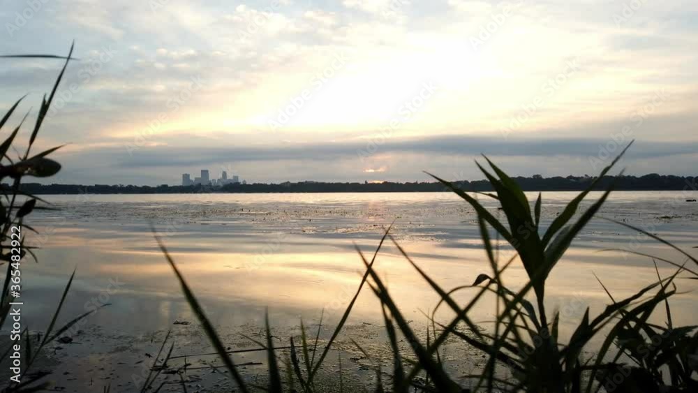 time lapse during a cloudy morning by the lake skyline of downtown minneapolis in the backgrand